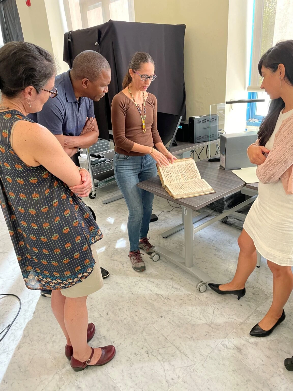Archivists and visitors examine a historical document displayed in the archive.