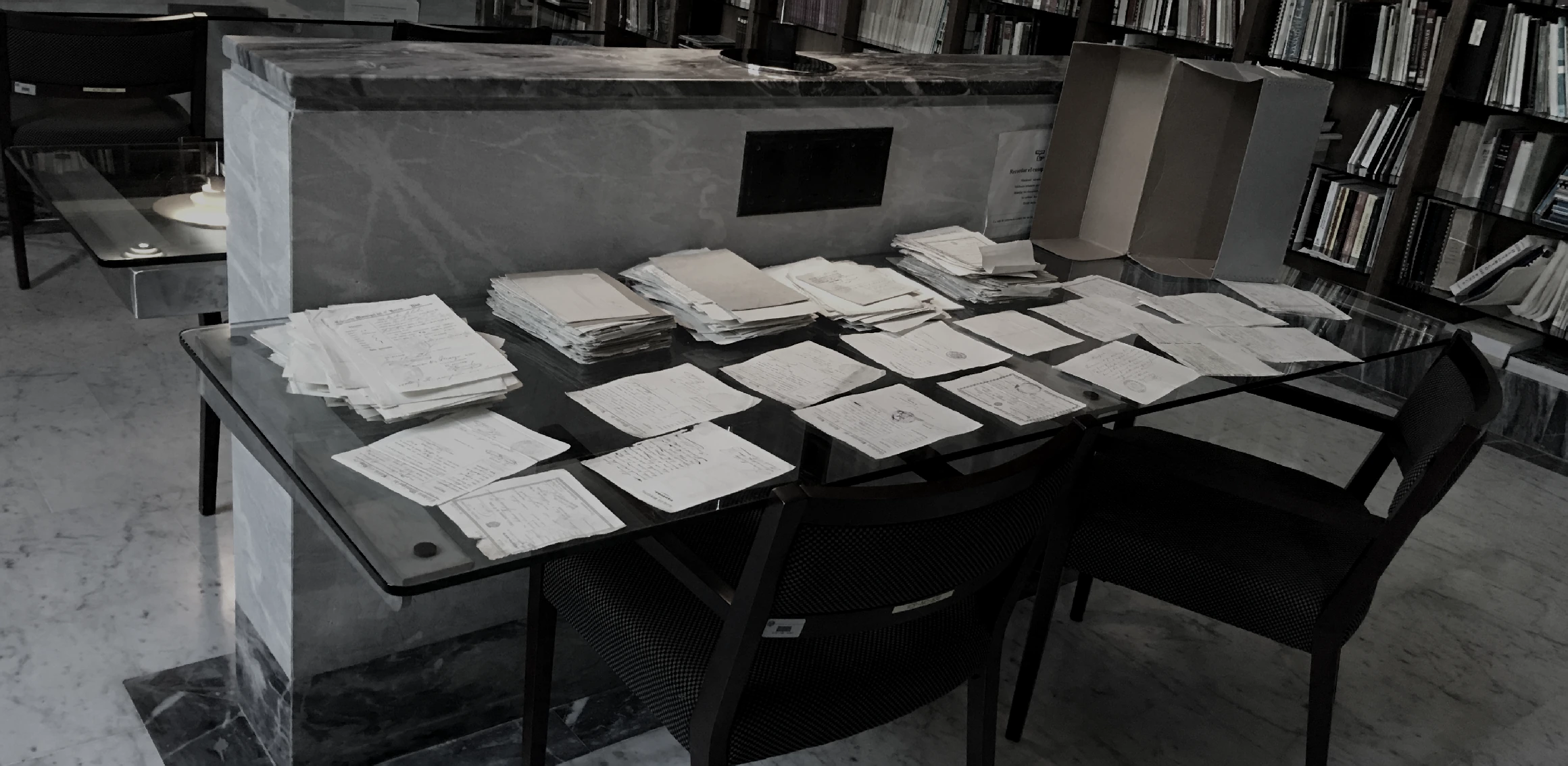 Archival documents arranged for consultation on a table in a records workspace.