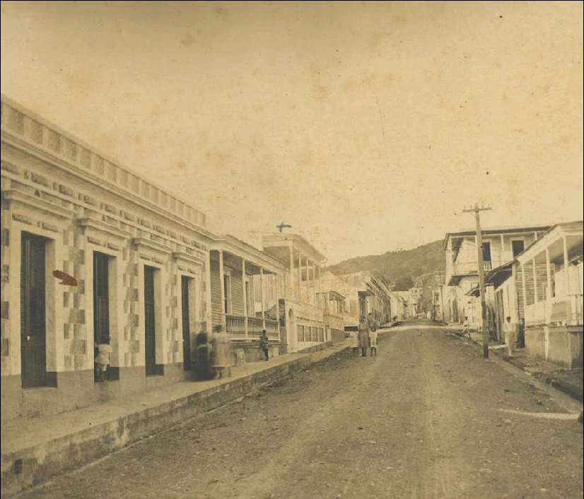 Historical Puerto Rican streetscape with buildings along both sides of a road.